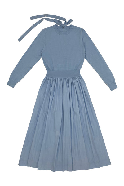 Blue dress with long sleeves and a tie at the neckline on a white background