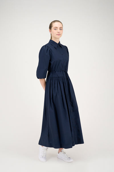 Woman wearing a navy dress on a white background